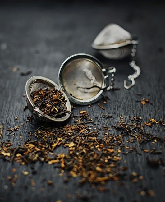 loose leaf tea on a metal spherical in cup strainers, used as meditation aids