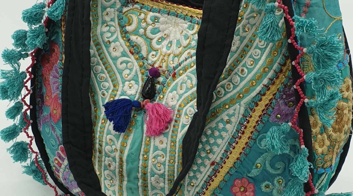 Patchwork hippy bag in teal blue with unique embroidery and a tassel trim. Fully lined with an embroidered black strap and floral panels.