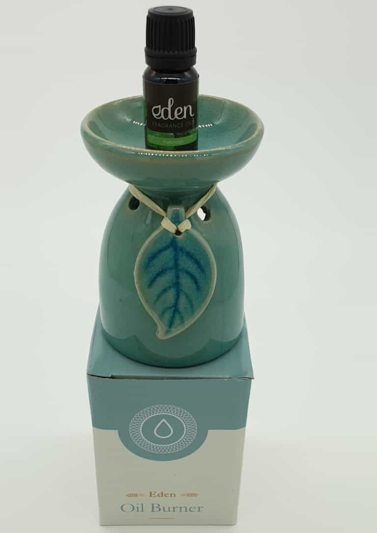 Eden ceramic oil burner with a wide top dish for oils, plus a leaf design hanging by rattan from the neck. It has a large hole at the back to place a tealight. Boxed with oil.