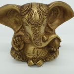 Bronze ganesha statue with large ears and a raised hand with carved om symbol on the palm