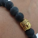 Natural carved slate black stone bracelet with gold buddha head bead. Stretch elastic. For men or for women.