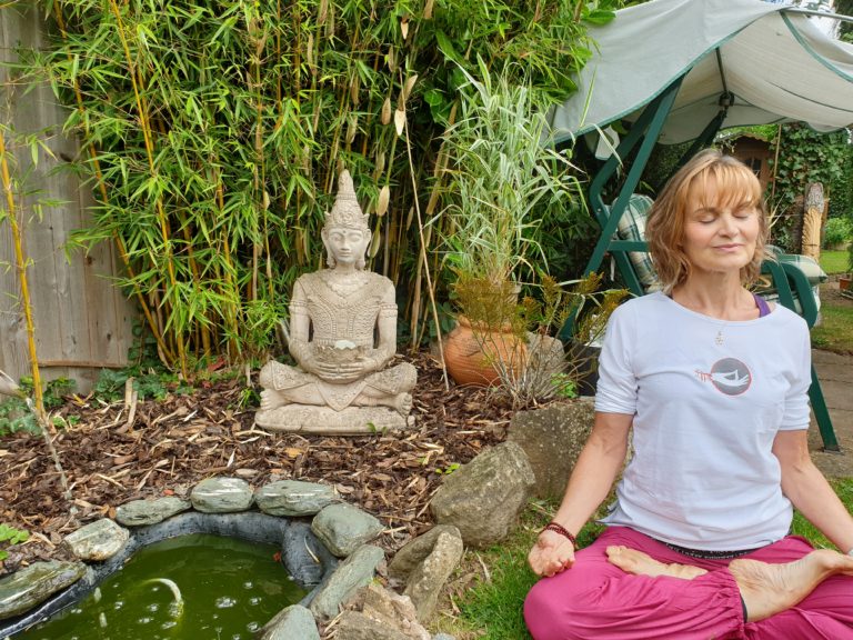 Try Yoga in the Garden. Here a Yoga teacher sits in lotus pose next to a budda statue and fountain in a back garden.