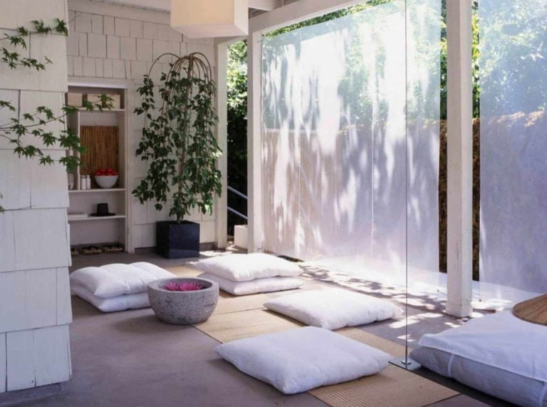 Beautiful yoga rooms don't have to be traditional. This white, minimalistic room with sheer drapes and floor cushions creates a perfectly zen atmosphere.