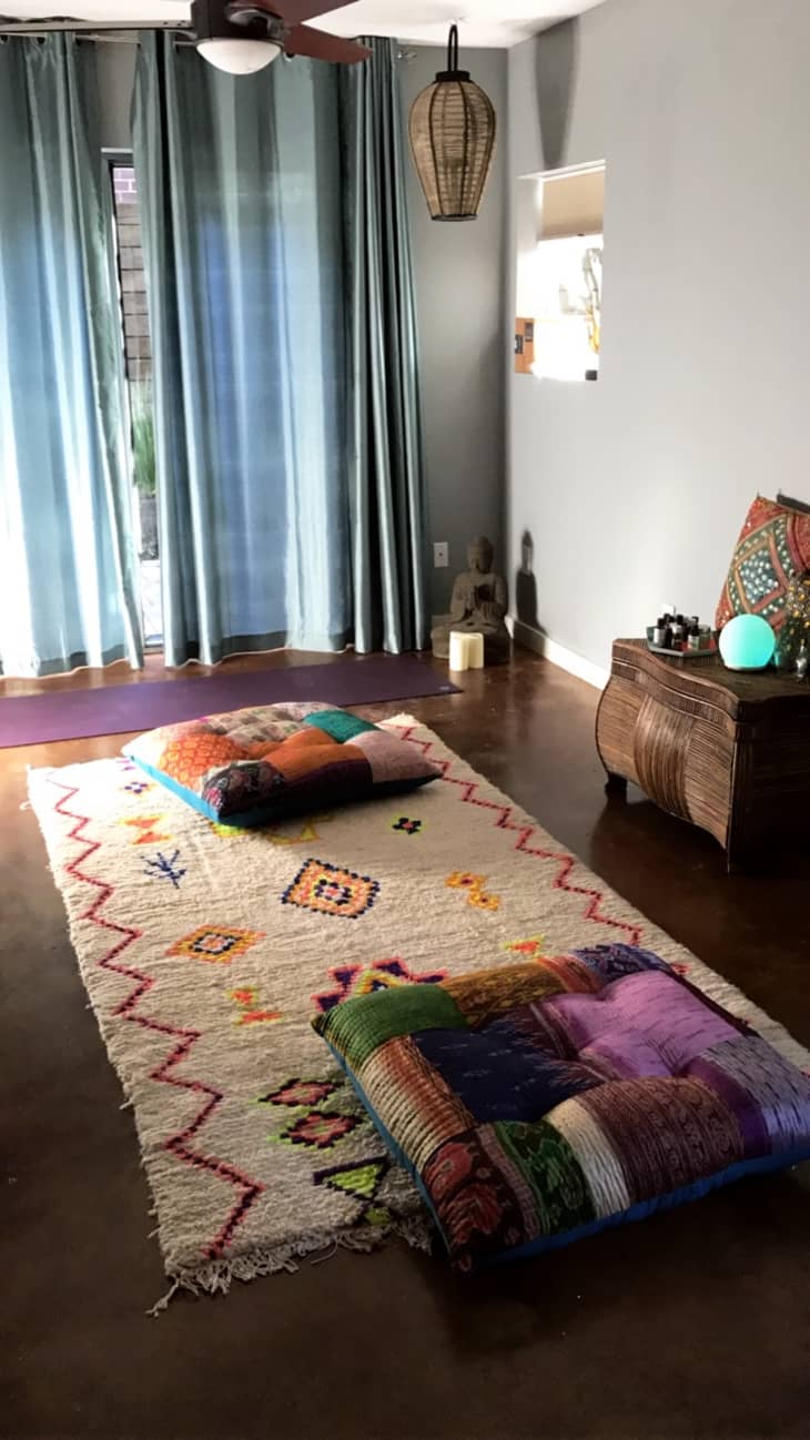 Beautiful yoga rooms like this are easy to put together. These bright floor cushions and funky patterned rug uplift the space without overwhelming it.