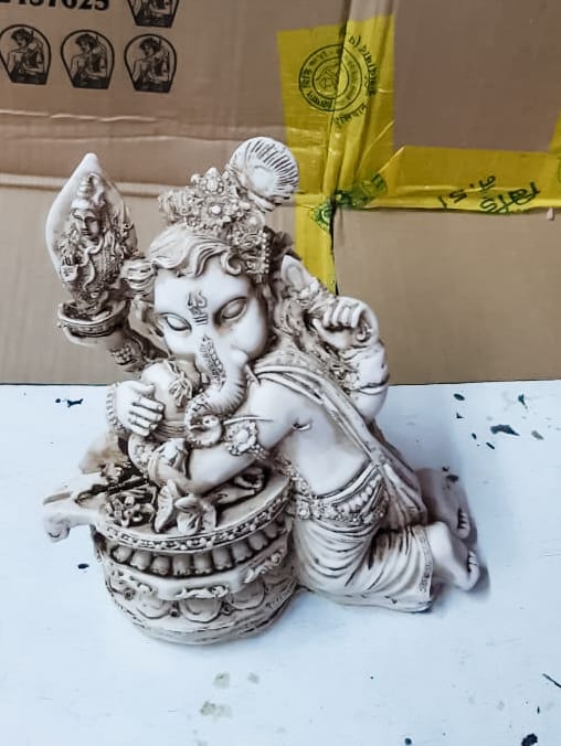 A grey clay statue of ganesha as a child.