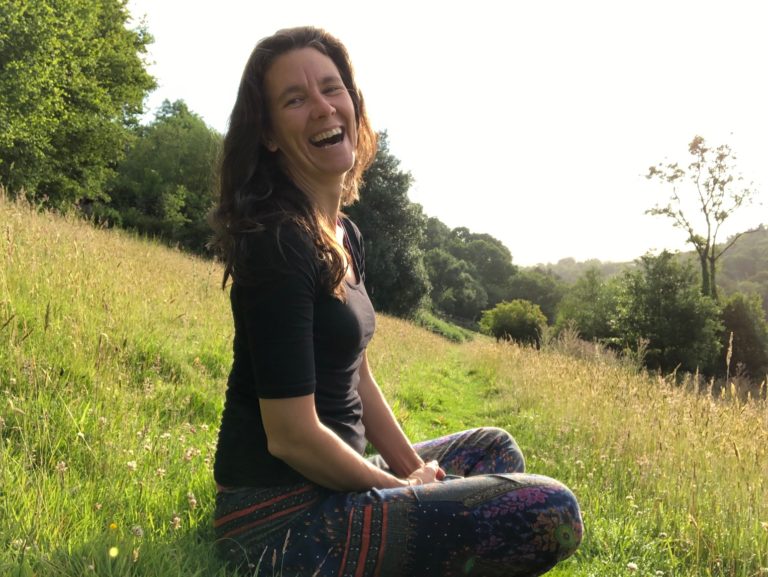 Yoga Teacher Terry Bruce interview sitting in the grass of a summer field.