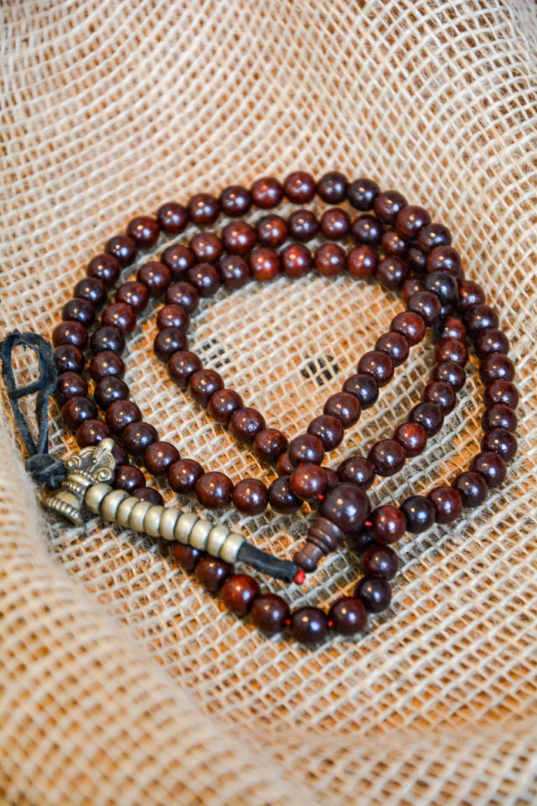 Rosewood mala prayer beads with a brass hammer-shaped hanging counter