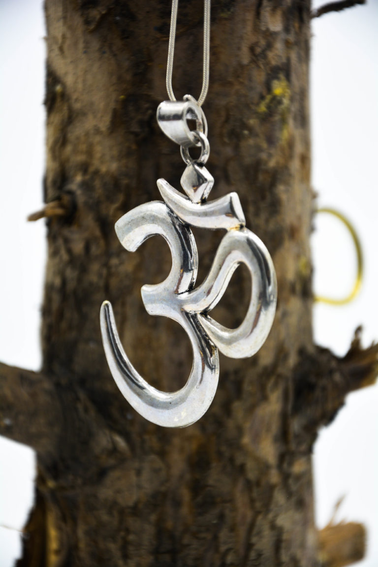 Large silver om symbol pendant hanging on a smooth snake chain