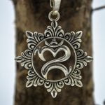 The new spiritual jewellery coming includes this Silver metal om symbol pendant with engraved flower petals around it.
