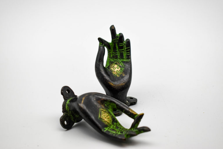 Bronze mudra door handle shown in a pair from different angles. Dark metal with a green patina effect and a gold diamond pattern on the palm. A plate with drilled holes is on the back to attach it.