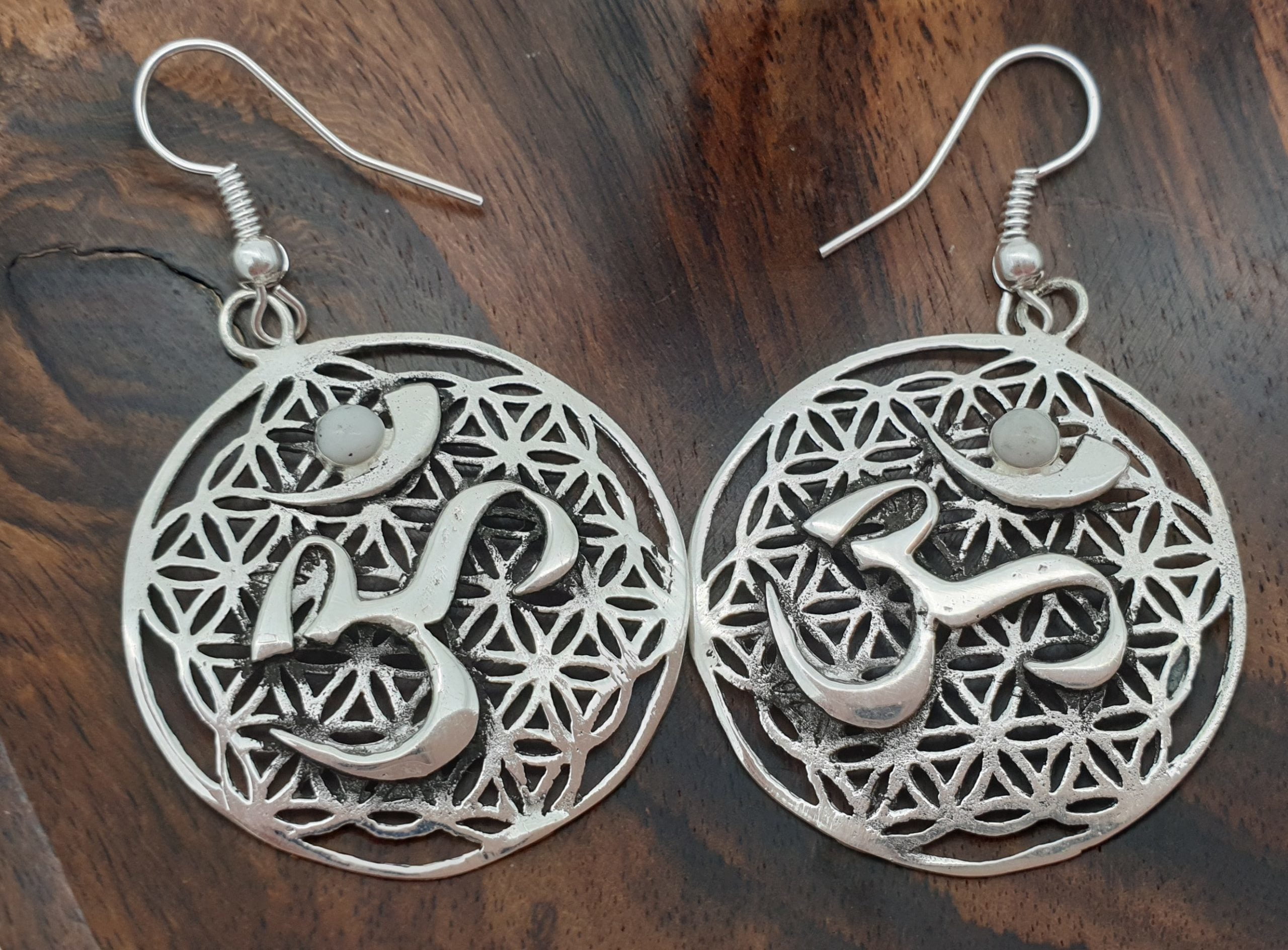 Round Silver Om Symbol Earrings On Flower Of Life Background