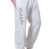 white yoga pants for men shown from the front with the term Yogi hand painted down the front leg. the model has his hands in the side pockets and the wide waist band is worn low