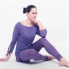 easy fit yoga leggings with pockets shown on a seated model in purple
