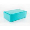 an aqua blue yoga block made from smooth soft touch foam with cut off edges on a white background