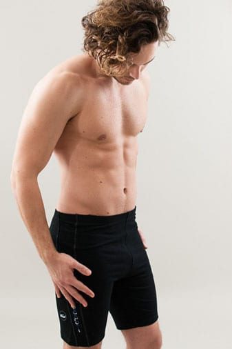 a model wearing black yoga shorts for men that are mid thigh length and slim fit with a hand painted blue yogi symbol on the leg