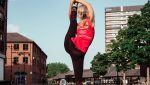 A yoga teacher doing standing splits by the coventry canal basin in our best seamless yoga leggings in black