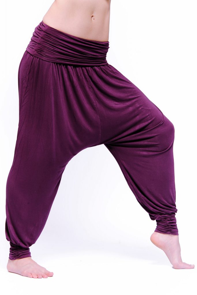 Comfort flow loose yoga pants with a low crotch and wide waist band. The fabric is a deep plum purple.
