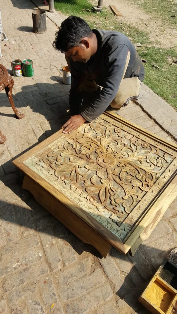 Artisan working on a carved table top