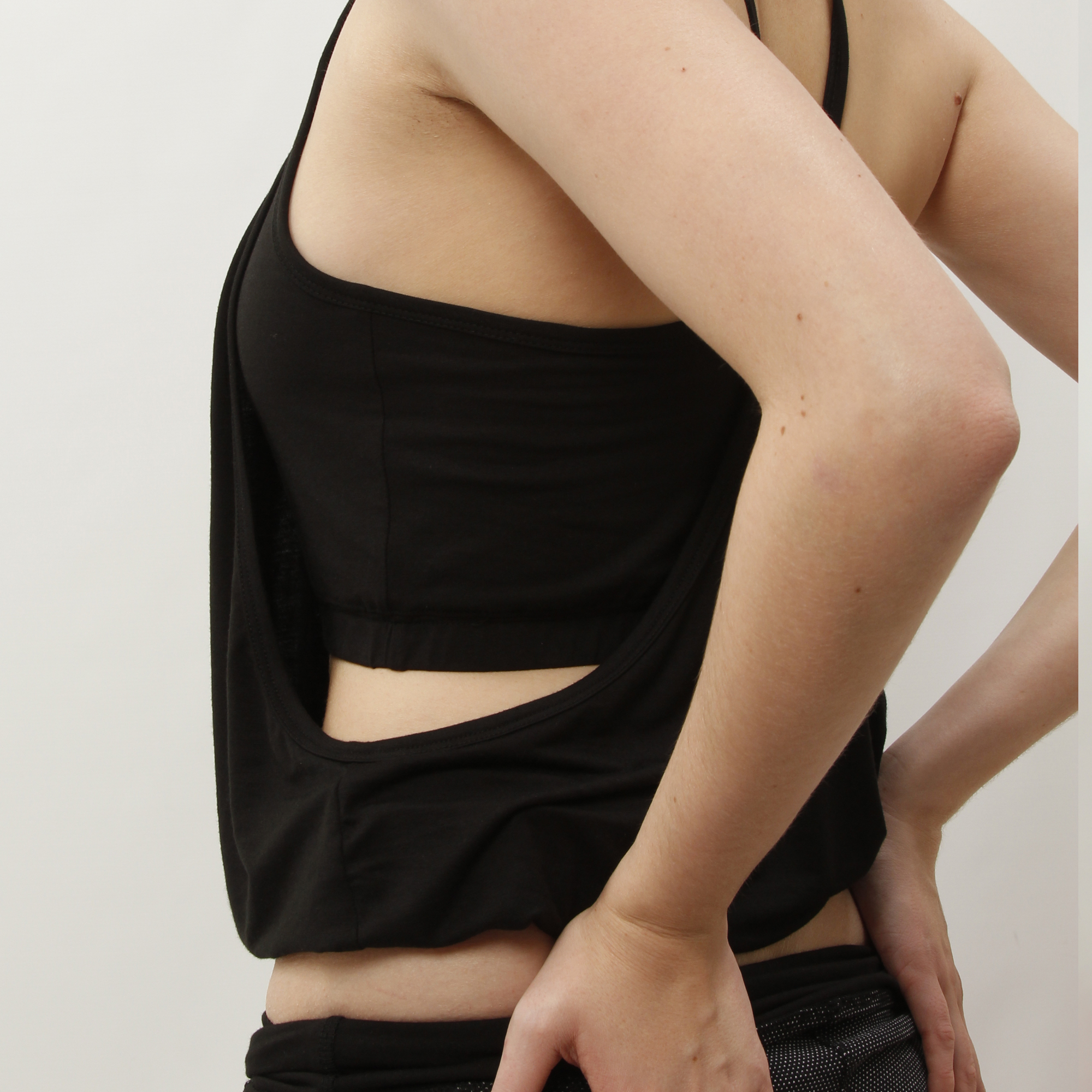 zen black organic tunic. a loose yoga top with a crop top layer and a covering layer with a wide bottom band